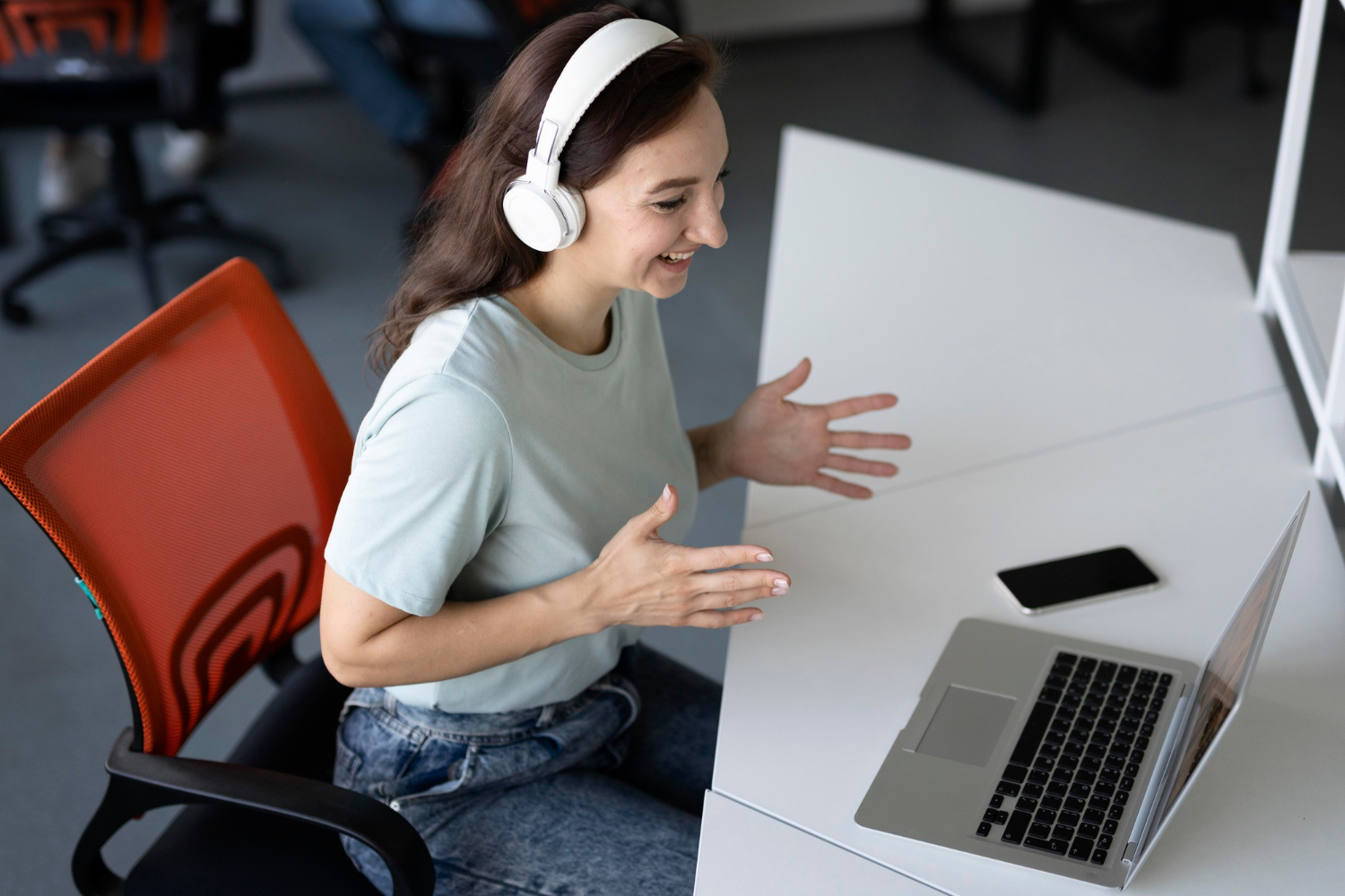 Women at work wearing headphones in front of a laptop